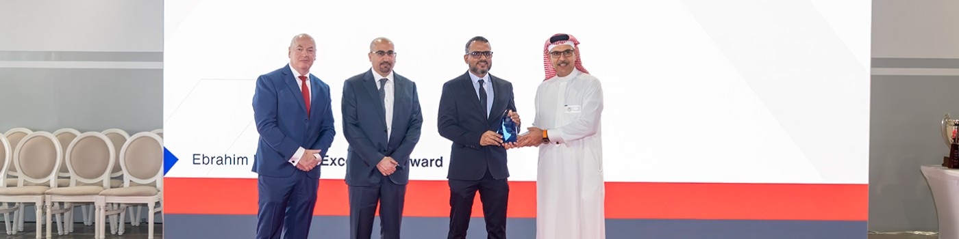 Nafsin Vattakandy receiving an Excellence Award trophy on stage at an Ebrahim K. Kanoo ceremony.